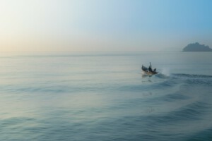 Small wooden fishing boat heading out to sea